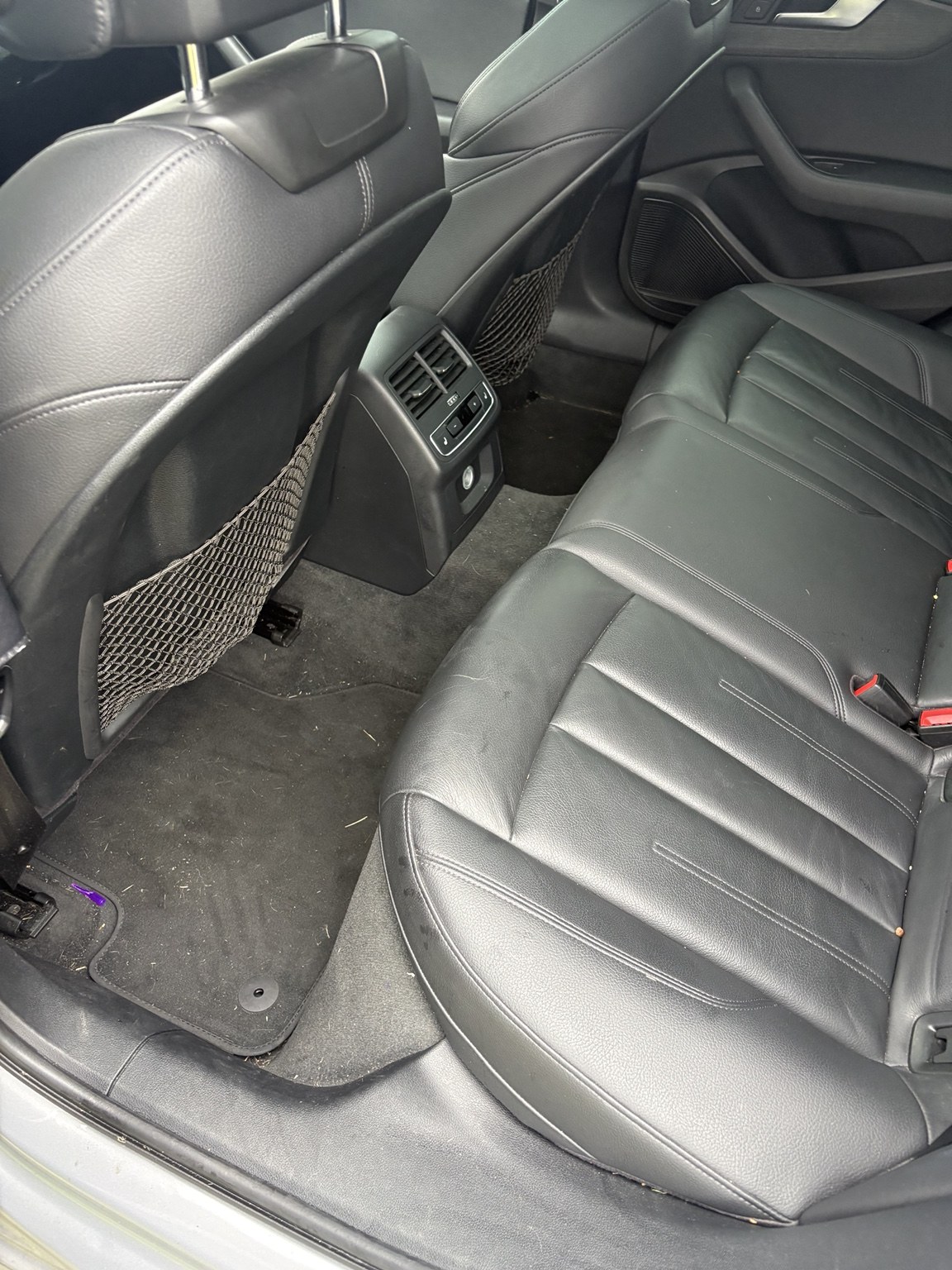 Rear seats and carpet before detailing, showing dirt and debris