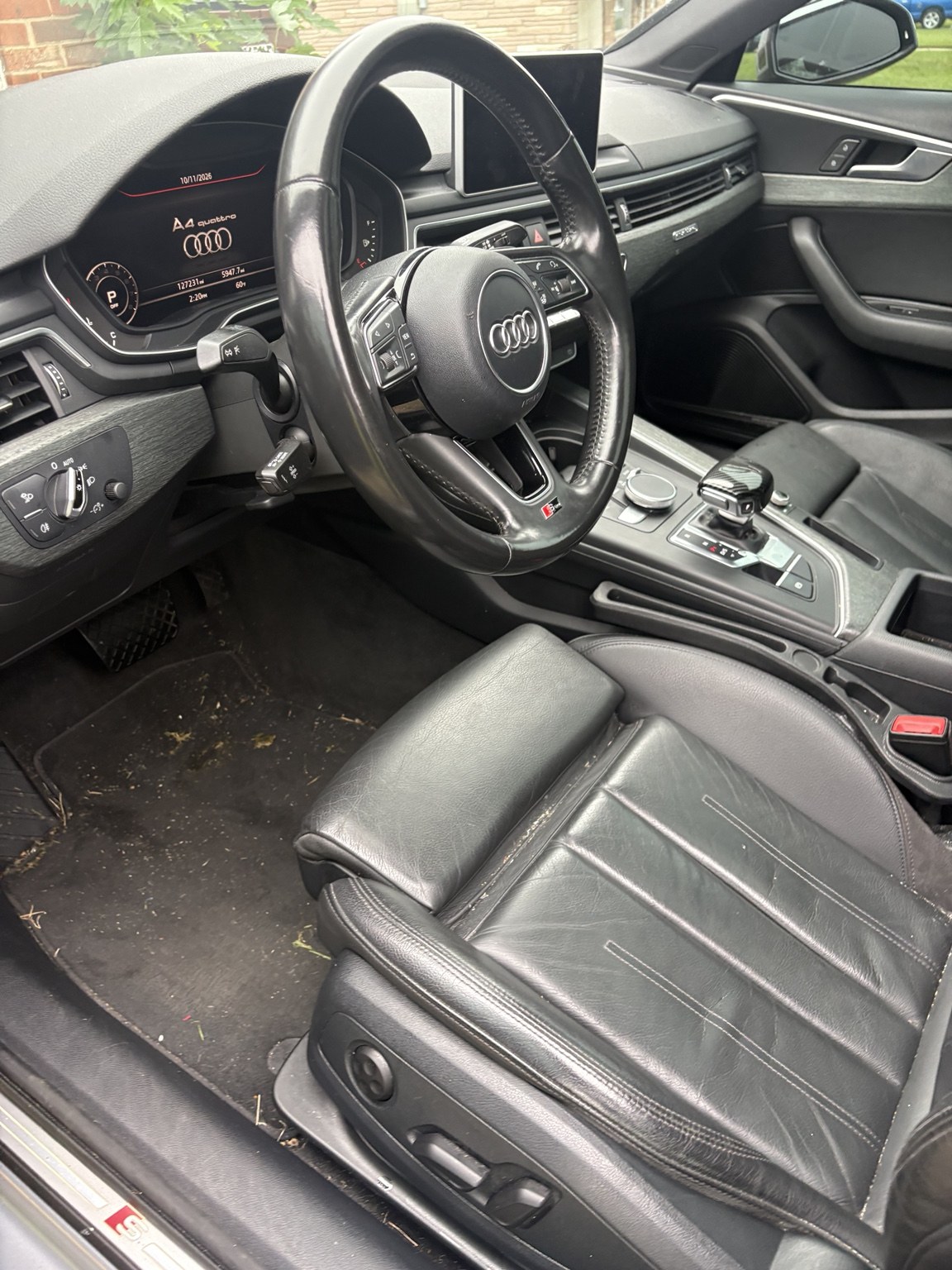 Audi driver seat and floor before detailing, showing dirt and debris